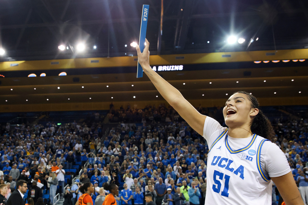 UCLA center Lauren Betts (51) reacts while holding up the UCLA bracket sticker after UCLA defeats Oklahoma State in the second round of the NCAA college basketball tournament, Monday, March 23, 2026, in Los Angeles. (AP Photo/Jessie Alcheh)