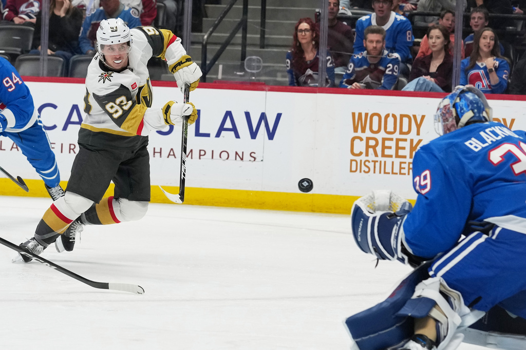 Vegas Golden Knights right wing Mitch Marner, left, puts a shot on Colorado Avalanche goaltender MacKenzie Blackwood in the second period of an NHL hockey game Saturday, April 11, 2026, in Denver. (AP Photo/David Zalubowski)