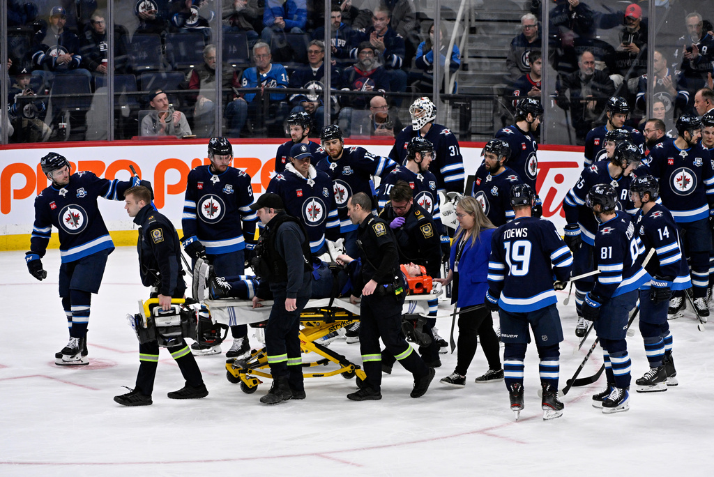 Winnipeg Jets' Haydn Fleury is helped off the ice after being injured against the Vegas Golden Knights during the first period of their NHL hockey game in Winnipeg, Tuesday Jan. 6, 2026. (Fred Greenslade/The Canadian Press via AP)