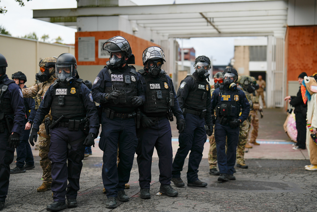 FILE - Law enforcement officers walk out of a U.S. Immigration and Customs Enforcement facility, Oct. 11, 2025, in Portland, Ore. (AP Photo/Jenny Kane, File)