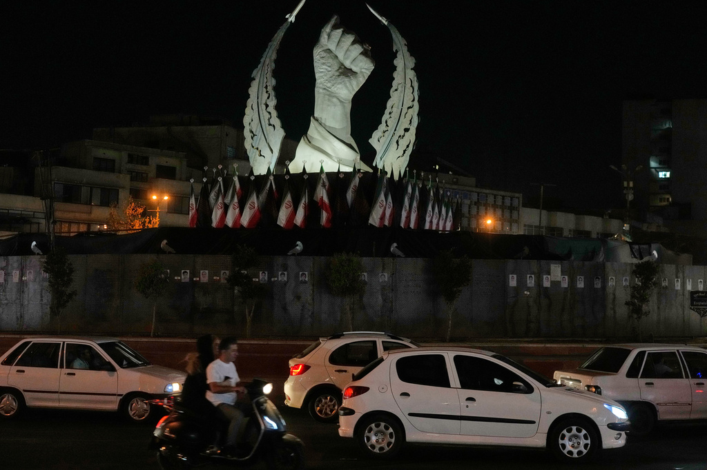 Vehicles drive past a monument depicting the clenched fist of the late Iranian Supreme Leader Ayatollah Ali Khamenei, who was killed in the U.S. and Israel strike on Feb. 28, in Islamic Revolution Square in Tehran, Sunday, July 19, 2026. (AP Photo/Vahid Salemi)