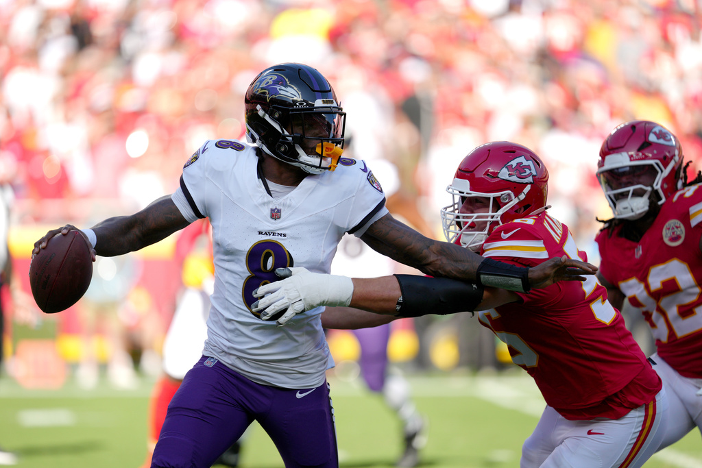 Baltimore Ravens quarterback Lamar Jackson (8) scrambles away from Kansas City Chiefs defensive end George Karlaftis during the first half of an NFL football game Sunday, Sept. 28, 2025, in Kansas City, Mo. (AP Photo/Ed Zurga)