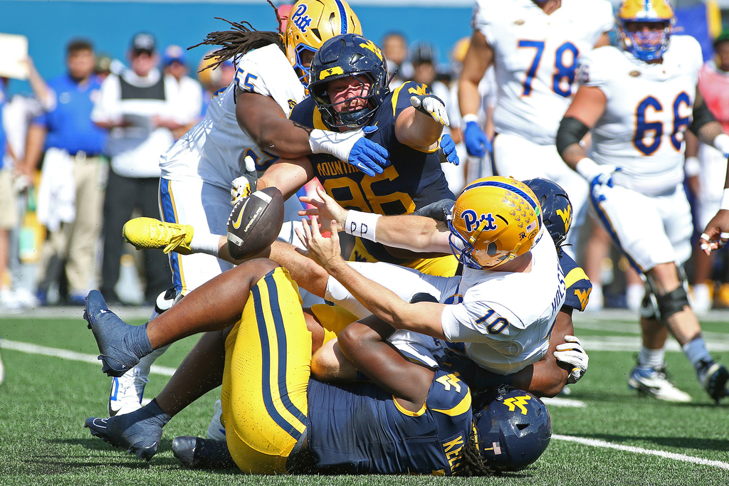 Pittsburgh quarterback Eli Holstein (10) fumbles during the first half of an NCAA college football game against West Virginia, Saturday, Sept. 13, 2025, in Morgantown, W.Va. (AP Photo/Kathleen Batten)