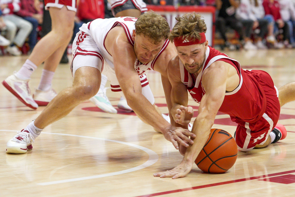 Nebraska guard Sam Hoiberg, right, goes after loose ball against Indiana forward Tucker DeVries during the first half of an NCAA college basketball game in Bloomington, Ind., Saturday, Jan. 10, 2026. (AP Photo/AJ Mast)