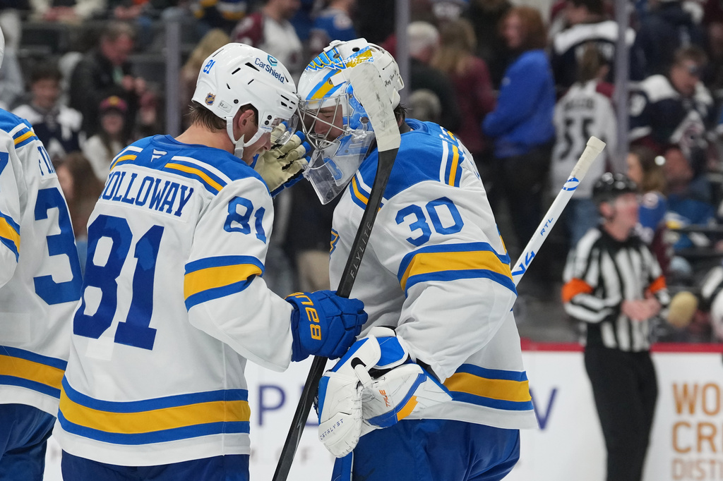 St. Louis Blues left wing Dylan Holloway (81) congratulates goaltender Joel Hofer (30) after defeating the Colorado Avalanche in an NHL hockey game Sunday, April 5, 2026, in Denver. (AP Photo/David Zalubowski)