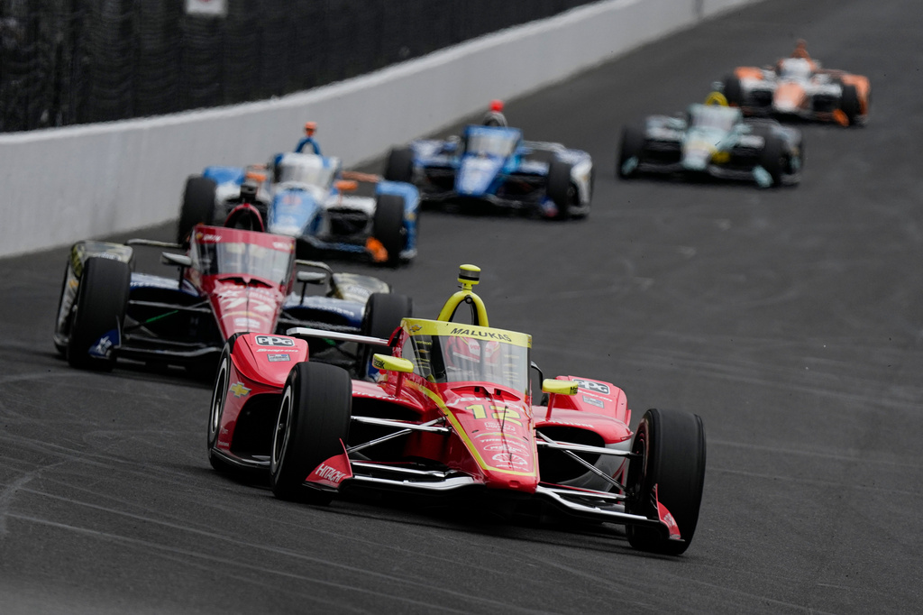 David Malukas leads a pack of cars into the first turn during practice for the Indianapolis 500 auto race at the Indianapolis Motor Speedway in Indianapolis, Monday, May 18, 2026. (AP Photo/Michael Conroy)