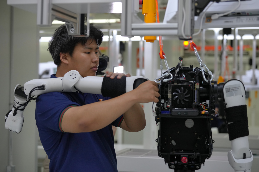 Workers assemble robot at the LY iTech Beijing Super Factory for Embodied Artificial Intelligence during a media tour in the Beijing E-Town on the outskirts of Beijing on May 29, 2026. (AP Photo/Andy Wong)