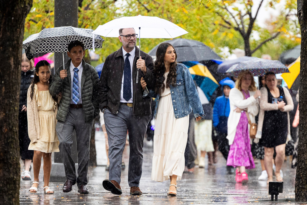 Jason Phelps, center, from Bakersfield, Calif., walks with his children, from left, Evan, Daniel and Mia, outside the Conference Center before the morning session of the 195th Semiannual General Conference of The Church of Jesus Christ of Latter-day Saints in Salt Lake City on Saturday, Oct. 4, 2025. (Isaac Hale/The Deseret News via AP)