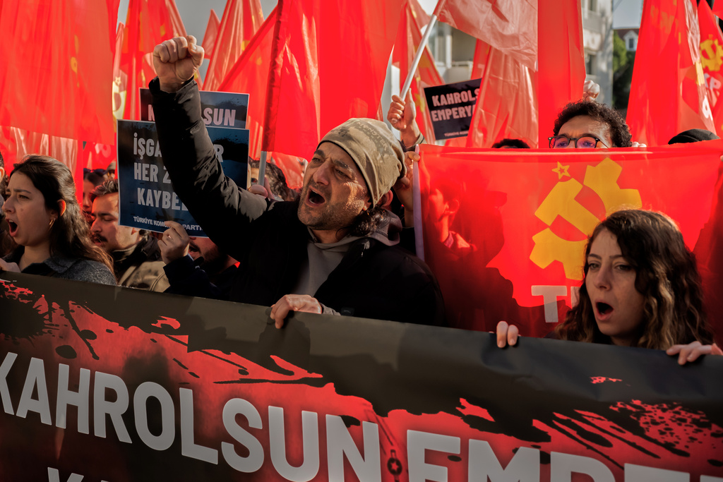 People chant slogans as they protest against U.S. and Israeli strikes on Iran, outside a NATO base in Izmir, Turkey, Saturday, Feb. 28, 2026. (AP Photo/Murat Kocabas)