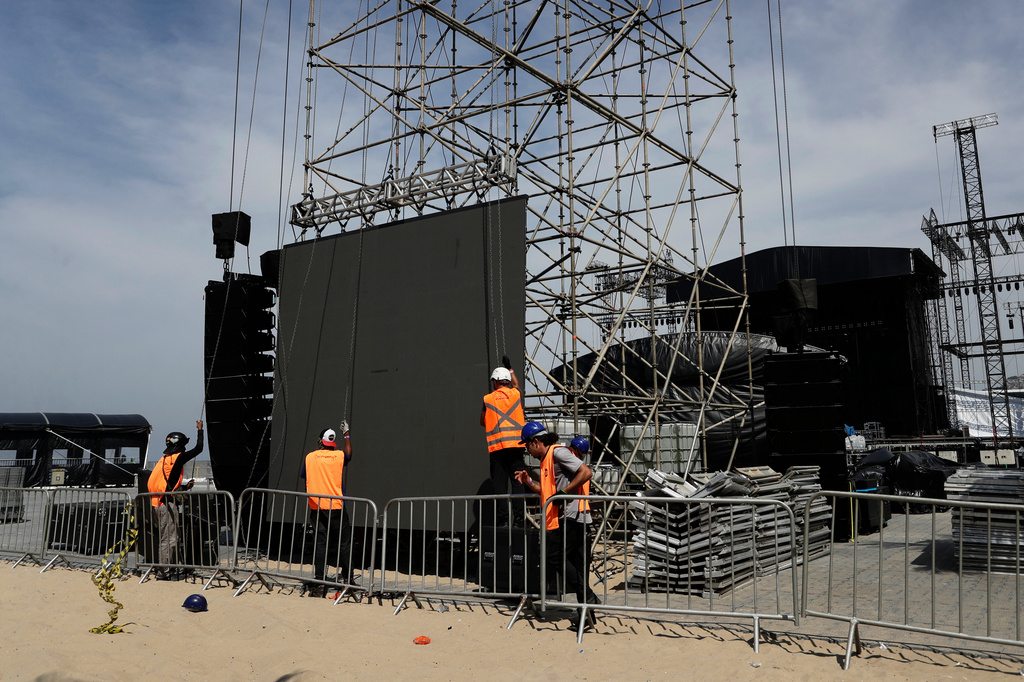 Workers resume construction on the stage for a concert by Colombian pop star Shakira after the death of a worker in an accident during setup a day prior, at Copacabana beach in Rio de Janeiro, Monday, April 27, 2026. (AP Photo/Bruna Prado)