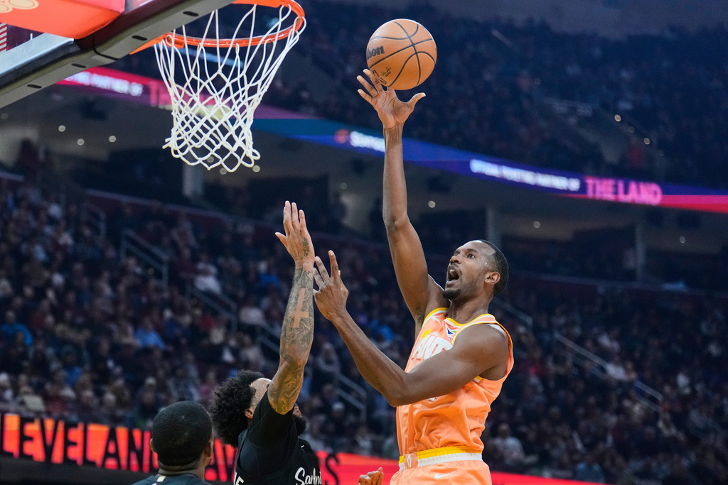 Cleveland Cavaliers center Evan Mobley, right, shoots over San Antonio Spurs forward Julian Champagnie, left, in the first half of an NBA basketball game Friday, Dec. 5, 2025, in Cleveland. (AP Photo/Sue Ogrocki)