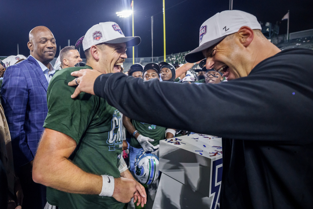 Tulane head coach Jon Sumrall, right, reacts with Tulane quarterback Jake Retzlaff (12) after winning the American Conference championship NCAA college football game against North Texas in New Orleans, Friday, Dec. 5, 2025. (AP Photo/Matthew Hinton)