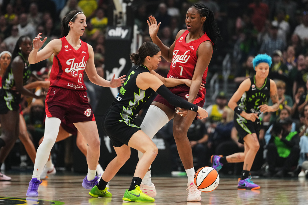 Seattle Storm guard Jade Melbourne, center, loses the ball against Indiana Fever guard Caitlin Clark, left, and center/forward Aliyah Boston, right, during the first half of a WNBA basketball game, Tuesday, July 28, 2026, in Seattle. (AP Photo/Lindsey Wasson)