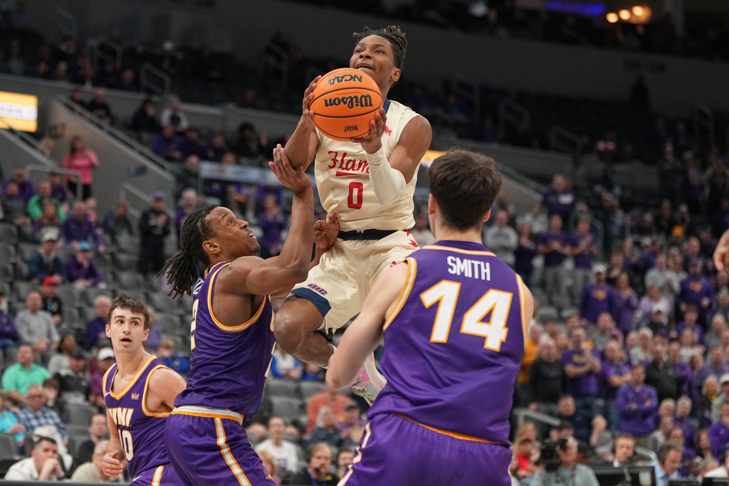 UIC's Ahmad Henderson II (0) heads to the basket between Northern Iowa's Geon Hutchins, left, and Tristan Smith (14) during the first half of the championship game in the Missouri Valley Conference NCAA college basketball tournament Sunday, March 8, 2026, in St. Louis. (AP Photo/Jeff Roberson)