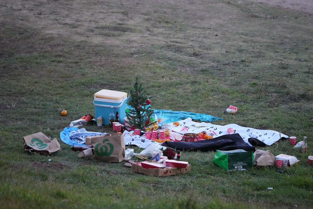 A small Christmas tree is at the center of an abandoned holiday picnic at Bondi Beach after a reported shooting in Sydney, Sunday, Dec. 14, 2025. (AP Photo/Mark Baker)
