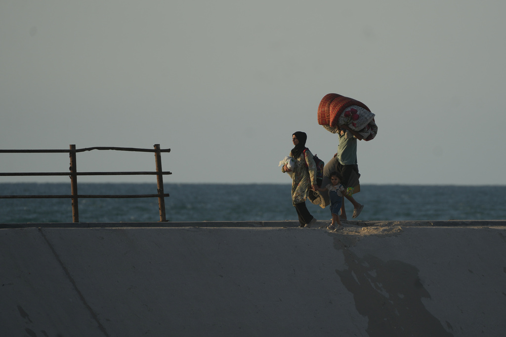 Displaced Palestinians flee northern Gaza carrying their belongings along the coastal road near Wadi Gaza, Thursday, Oct. 2, 2025. (AP Photo/Abdel Kareem Hana)