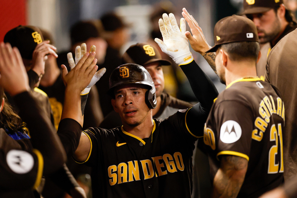 San Diego Padres' Freddy Fermin (54) is greeted by teammates after scoring during the eighth inning of a baseball game against the Los Angeles Angels, Saturday, April 18, 2026, in Anaheim, Calif. (AP Photo/Caroline Brehman)