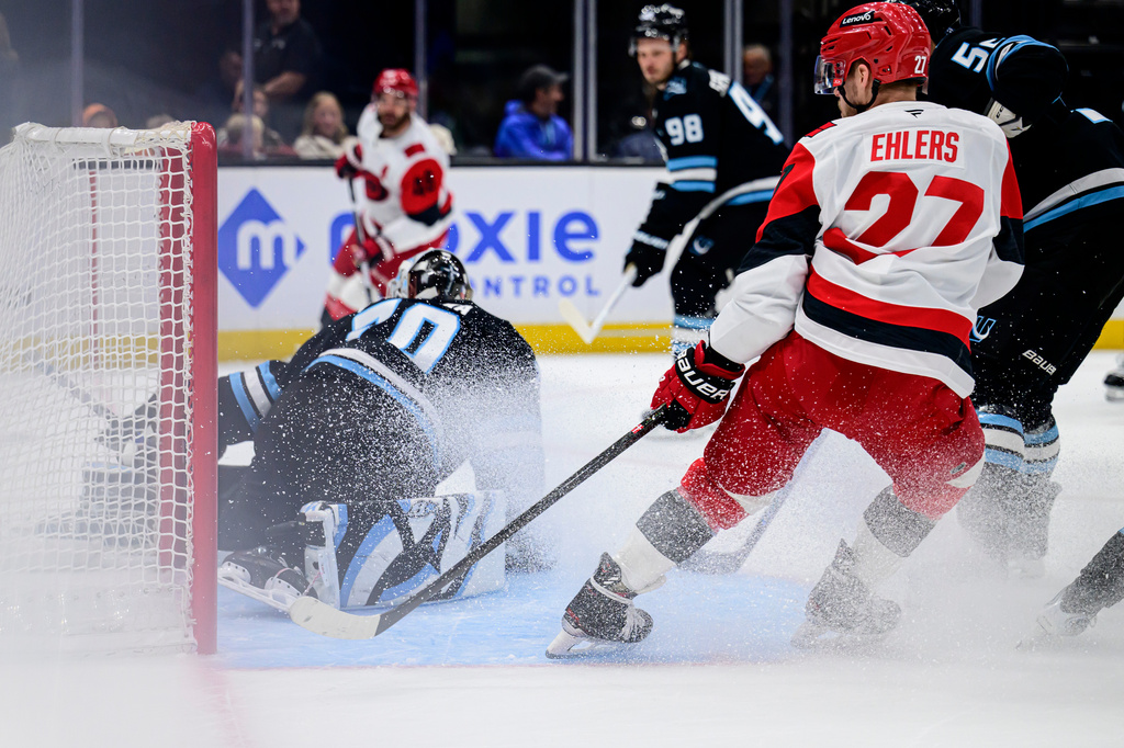 Carolina Hurricanes left wing Nikolaj Ehlers (27) looks to tip in the puck past Utah Mammoth goaltender Karel Vejmelka, left, during the first period of an NHL hockey game, Saturday, April 11, 2026, in Salt Lake City. (AP Photo/Tyler Tate)