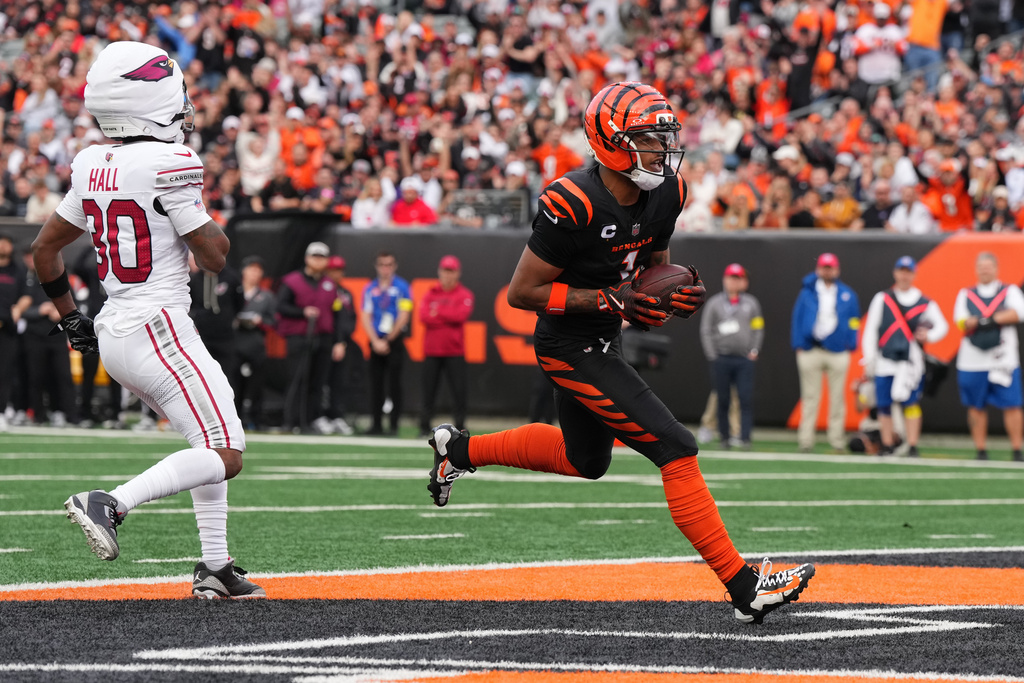 Cincinnati Bengals wide receiver Ja'Marr Chase, right, scores a touchdown during the first half of an NFL football game against the Arizona Cardinals, Sunday, Dec. 28, 2025, in Cincinnati. (AP Photo/Jeff Dean)