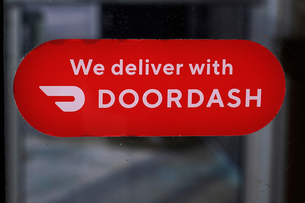 FILE - A DoorDash sign is posted on a door, Feb. 27, 2023, in Methuen, Mass. (AP Photo/Charles Krupa, File)
