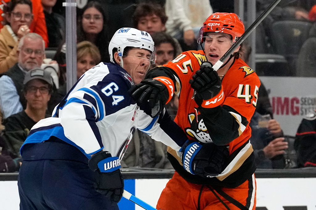Winnipeg Jets defenseman Logan Stanley, left, is hit in the face by Anaheim Ducks right wing Beckett Sennecke during the first period of an NHL hockey game, Sunday, Nov. 9, 2025, in Anaheim, Calif. (AP Photo/Mark J. Terrill)