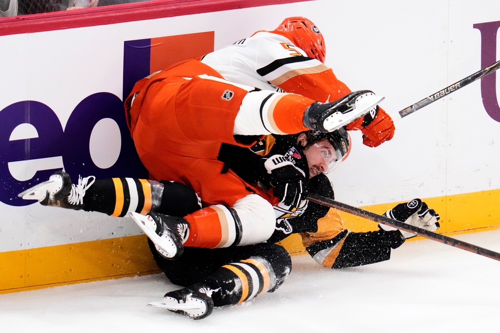 Anaheim Ducks' Olen Zellweger, top, collides with Pittsburgh Penguins' Connor Dewar during the first period of an NHL hockey game in Pittsburgh, Tuesday, Dec. 9, 2025. (AP Photo/Gene J. Puskar)