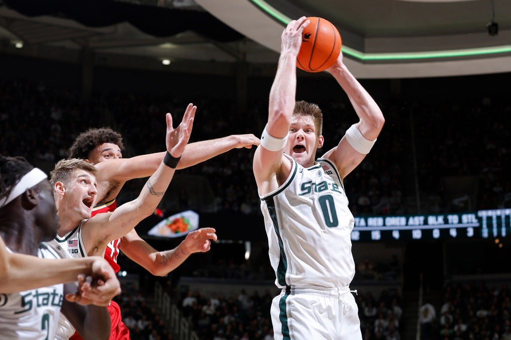 Michigan State forward Jaxon Kohler (0), right, grabs a rebound against Maryland center Collin Metcalf (45), rear, as Michigan State center Carson Cooper and guard Kur Teng, left, watch during the first half of an NCAA college basketball game, Saturday, Jan. 24, 2026, in East Lansing, Mich. (AP Photo/Al Goldis)