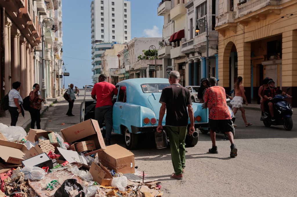 People push a broken-down, classic American car past a pile of trash in Havana, Cuba, Wednesday, June 17, 2026. (AP Photo/Jorge Luis Banos)