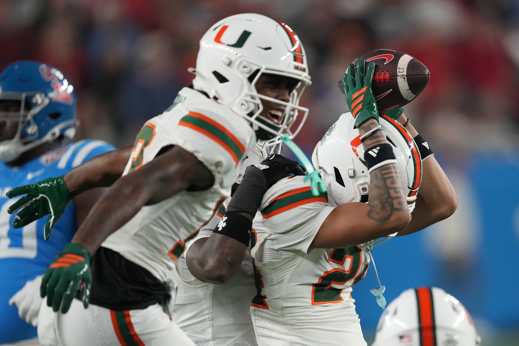 Miami defensive lineman Artavius Jones (42) and linebacker Wesley Bissainthe (31) react after a play during the second half of the Fiesta Bowl NCAA college football playoff semifinal game against Mississippi, Thursday, Jan. 8, 2026, in Glendale, Ariz. (AP Photo/Ross D. Franklin)
