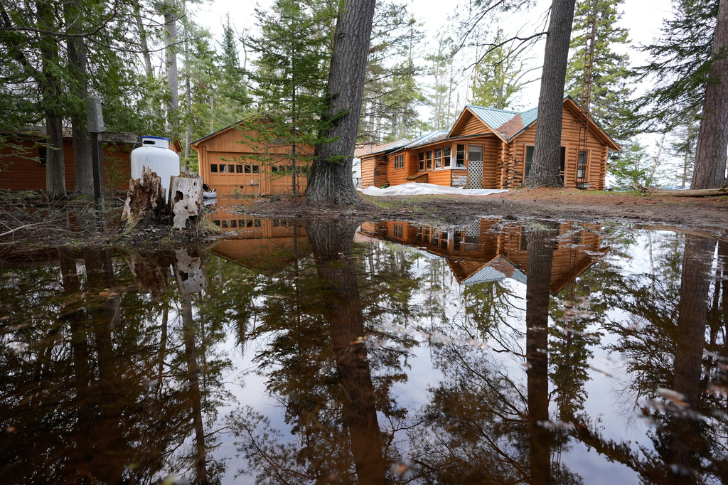 A home is surrounded by water from recent floods at Black Lake on Wednesday, April 29, 2026, in Grant Township, Mich. (AP Photo/Paul Sancya)