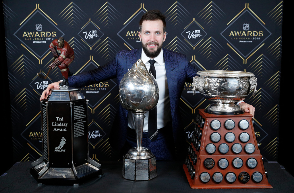 FILE - Tampa Bay Lightning's Nikita Kucherov poses with, from left, the Ted Lindsay Award, Hart Memorial Trophy and the Art Ross Trophy after winning the honors at the NHL Awards, onJune 19, 2019, in Las Vegas. (AP Photo/John Locher, File)