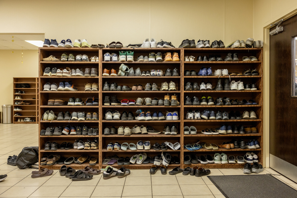 Hundreds of shoes fill the shelves for prayer at the Islamic Society of Tulsa, Friday, Feb. 13, 2026, in Tulsa, Okla. (AP Photo/Brittany Bendabout)
