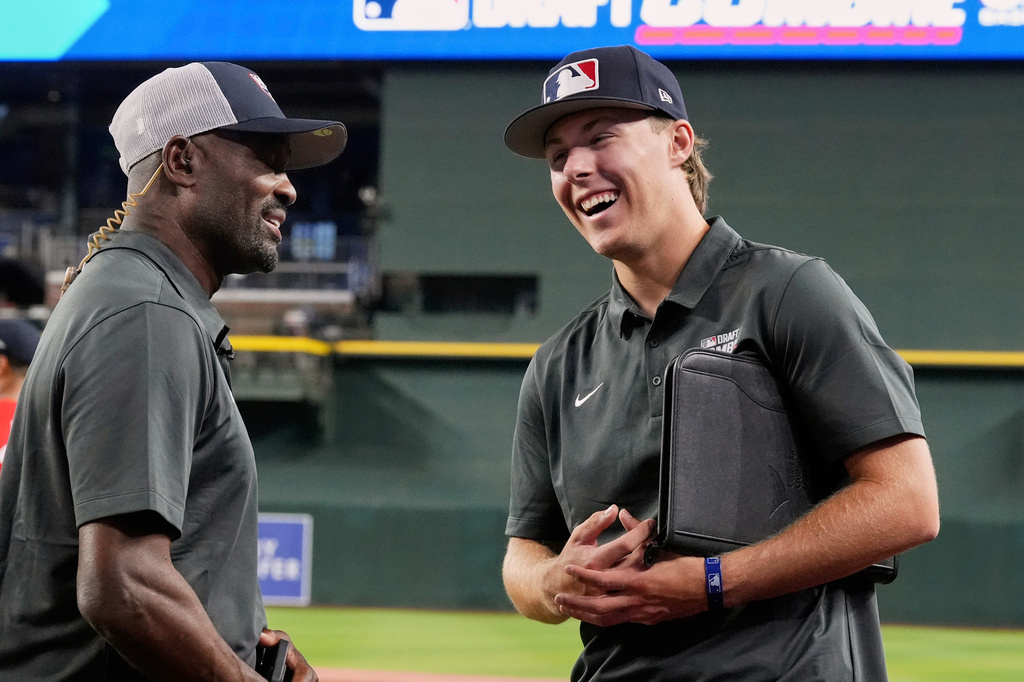 FILE - Grady Emerson, right, a shortstop from Fort Worth Christian High School, talks with former MLB player and current baseball commentator Harold Reynolds at the MLB baseball combine in Phoenix, June 23, 2026. (AP Photo/Ross D. Franklin, File)