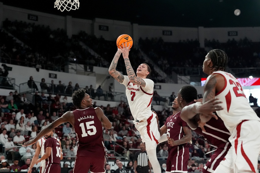Arkansas forward Trevon Brazile (7) leans into his shot while defended by Mississippi State players during the first half of an NCAA college basketball game, Saturday, Feb. 7, 2026, in Starkville, Miss. (AP Photo/Rogelio V. Solis)