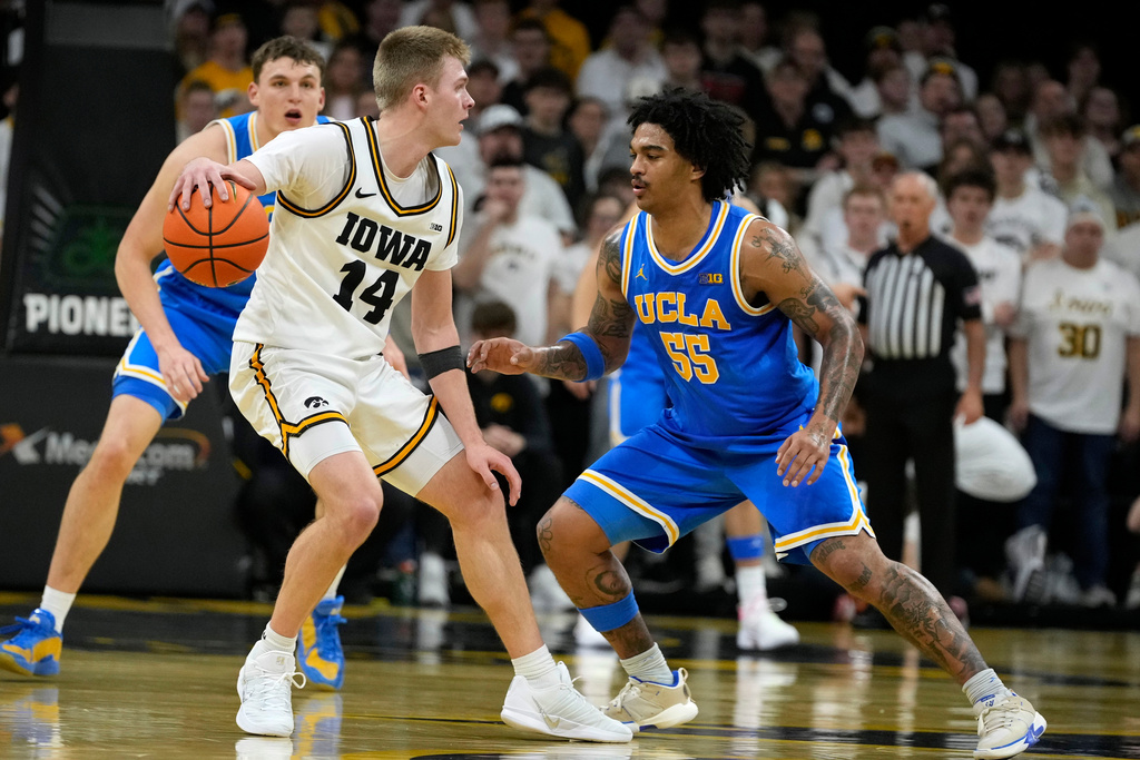 Iowa guard Bennett Stirtz (14) drives around UCLA guard Skyy Clark (55) during the first half of an NCAA college basketball game, Saturday, Jan. 3, 2026, in Iowa City, Iowa. (AP Photo/Charlie Neibergall)