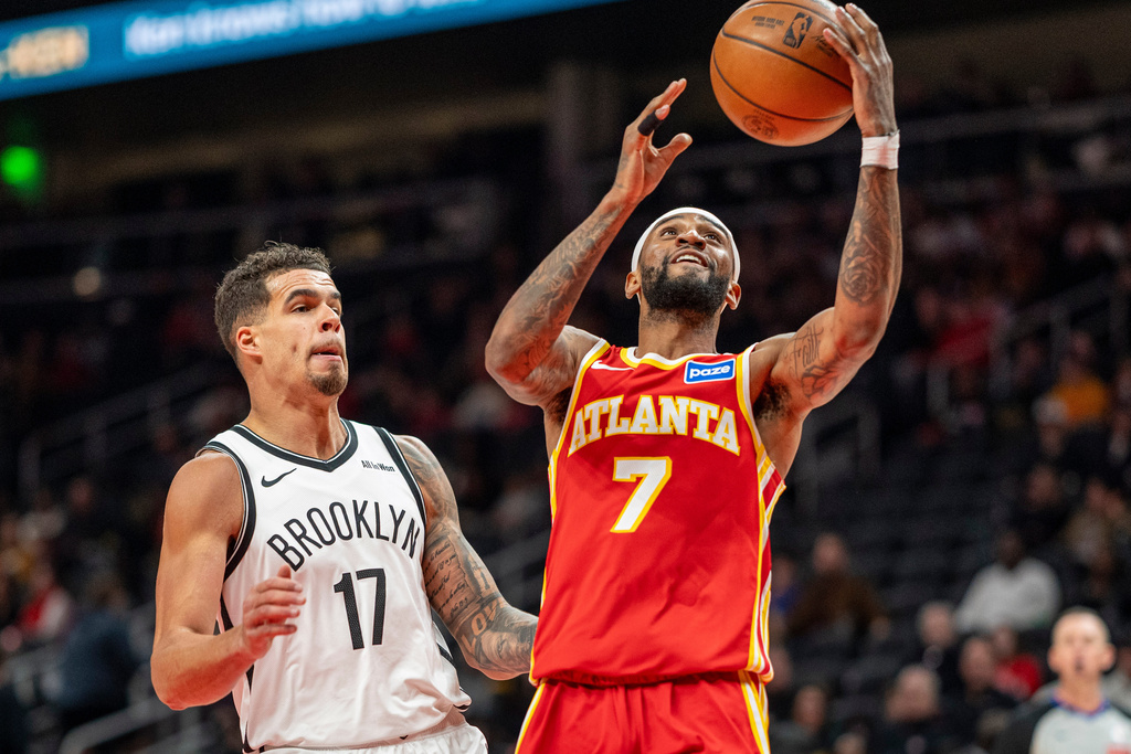 Atlanta Hawks guard Nickeil Alexander-Walker (7), right, attempts a basket against Brooklyn Nets forward Michael Porter Jr. (17), left, during the first half of an NBA basketball game, Sunday, Feb. 22, 2026, in Atlanta. (AP Photo/Erik Rank)