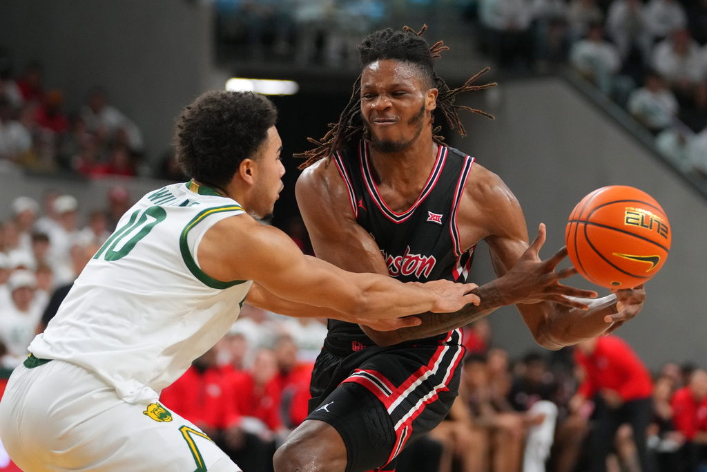 Houston forward Joseph Tugler, right, is fouled by Baylor guard Isaac Williams IV during the first half of an NCAA college basketball game Saturday, Jan. 10, 2026, in Waco. (AP Photo/Julio Cortez)