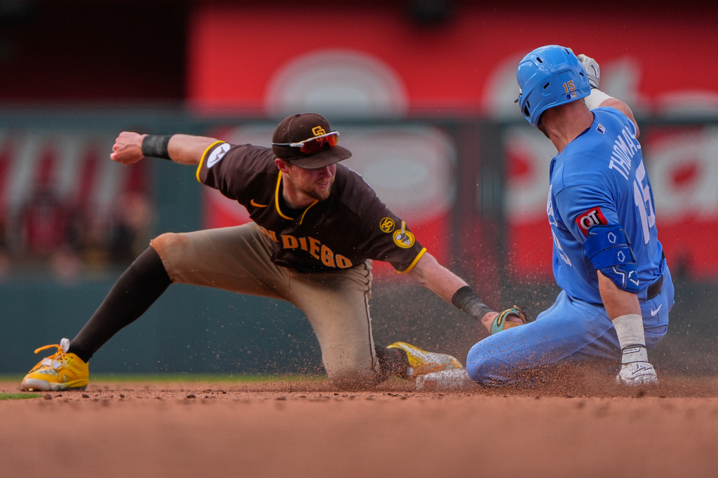 Kansas City Royals' Lane Thomas (15) beats the tag at second by San Diego Padres second baseman Jake Cronenworth after hitting a double during the eighth inning of a baseball game Saturday, July 18, 2026, in Kansas City, Mo. (AP Photo/Charlie Riedel)