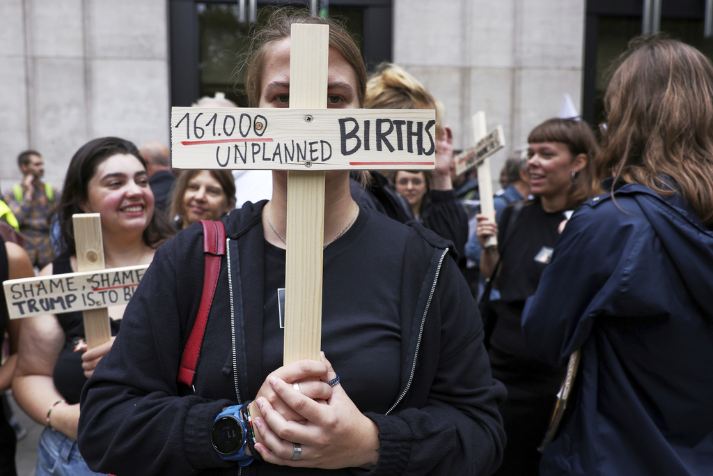 Participants from various women's rights organizations hold signs as they demonstrate regarding the destruction of family planning supplies stockpiled in Belgium, near the U.S. embassy in Brussels, Thursday, Sept. 18, 2025. (AP Photo/Omar Havana)