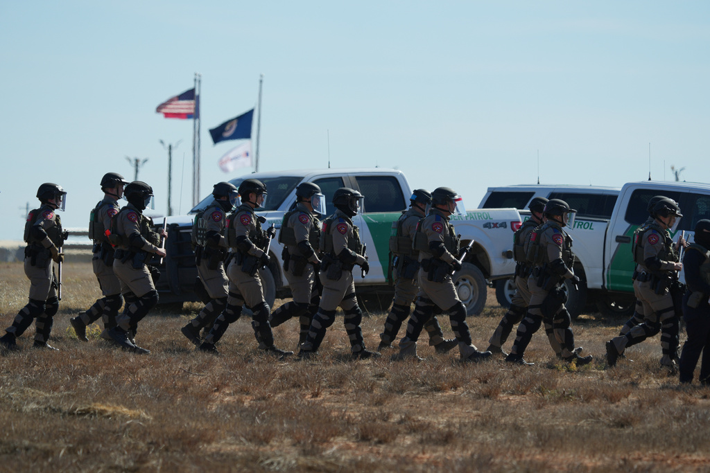 Texas state troopers wearing riot gear arrive to help disperse protesters gathered outside the South Texas Family Residential Center detention facility where Liam Ramos and his father are being detained in Dilley, Texas, Wednesday, Jan. 28, 2026. (AP Photo/Eric Gay)