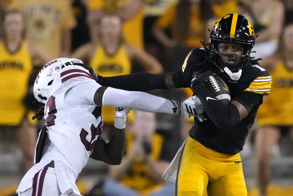 Iowa wide receiver KJ Parker (1) runs from Massachusetts safety Zeraun Daniel, left, after catching a pass during the second half of an NCAA college football game, Saturday, Sept. 13, 2025, in Iowa City, Iowa. (AP Photo/Charlie Neibergall)
