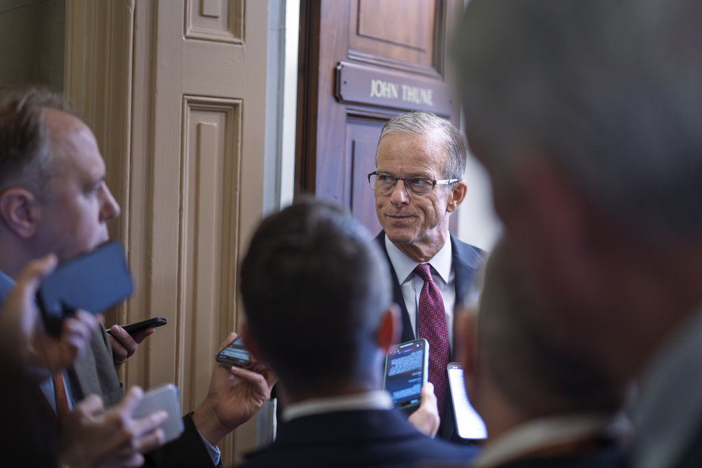 Senate Majority Leader John Thune, R-S.D., is met by reporters as he walks to his office while Congress works on a government funding solution, at the Capitol in Washington, Thursday, Sept. 18, 2025. (AP Photo/J. Scott Applewhite)