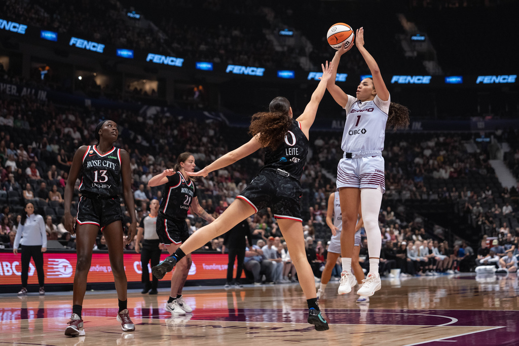 Toronto Tempo's Kiki Rice (1) shoots the ball as Portland Fire's Carla Leite (0) defends and Nyadiew Puoch (13) watches during the first half of a WNBA basketball game in Vancouver, British Columbia, Friday, Aug. 21, 2026. (Ethan Cairns/The Canadian Press via AP)