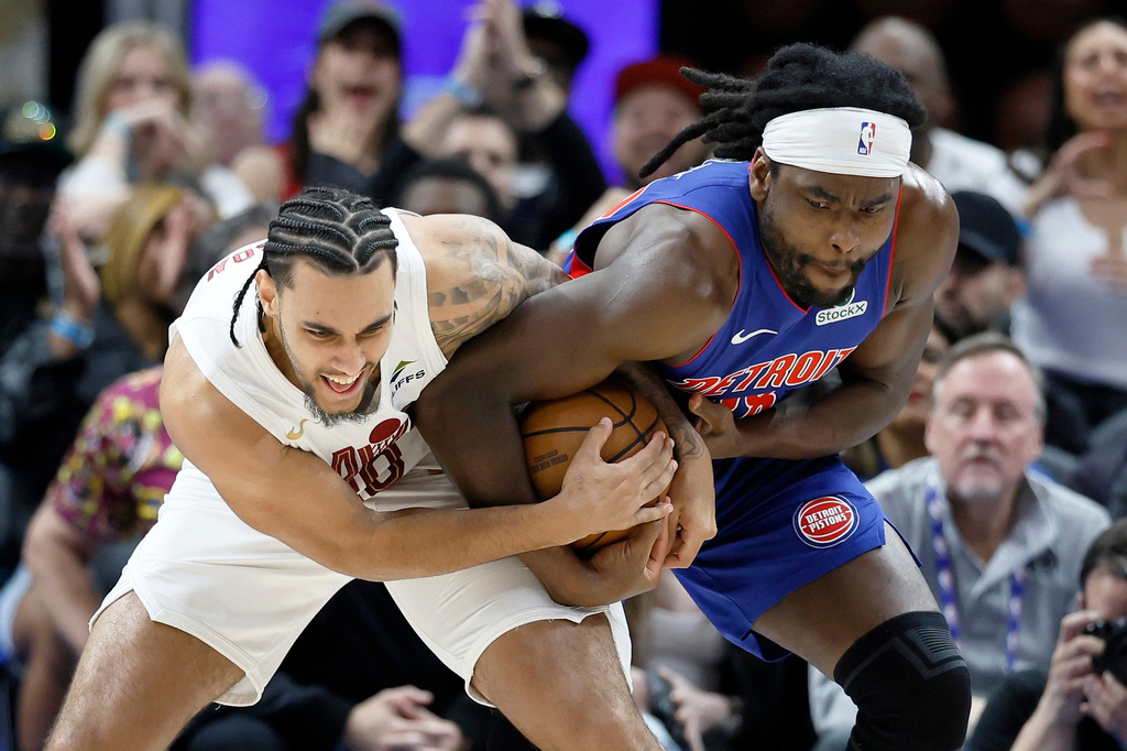 Cleveland Cavaliers guard Jaylon Tyson, left, and Detroit Pistons forward Isaiah Stewart fight over a ball during the first half in Game 5 of a second-round NBA playoffs basketball series, Wednesday, May 13, 2026, in Detroit. (AP Photo/Duane Burleson)