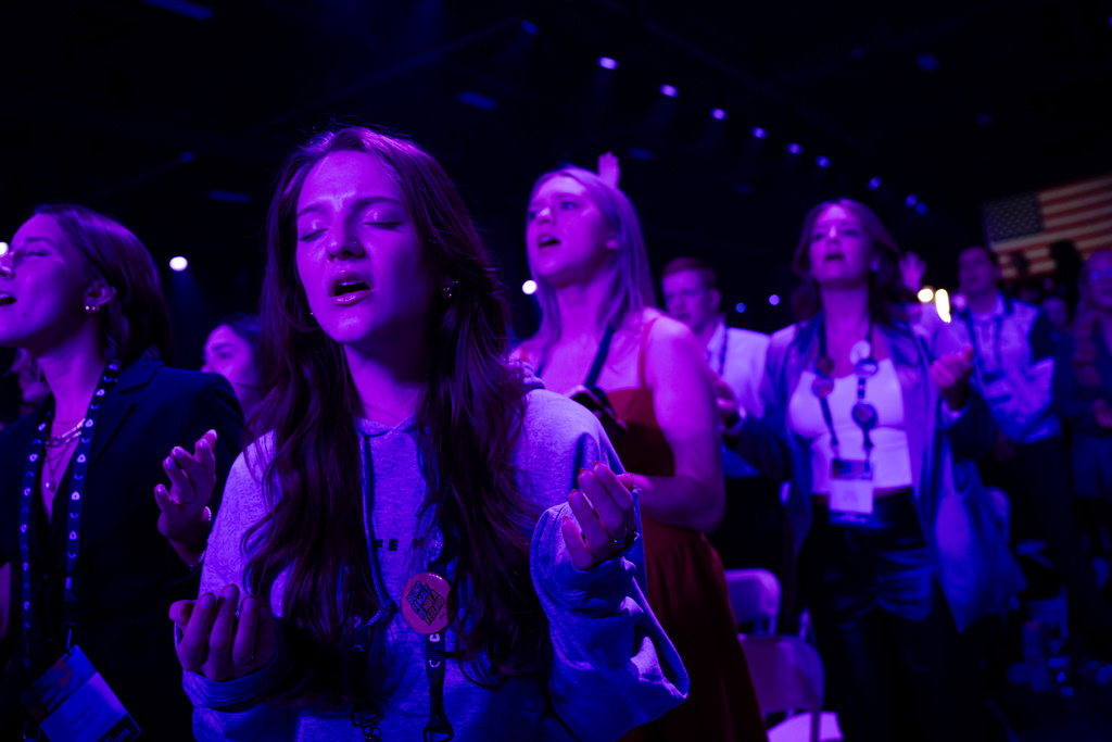 Attendees sing and pray during Faith Night worship events at Turning Point USA's AmericaFest 2025, Saturday, Dec. 20, 2025, in Phoenix. (AP Photo/Jon Cherry)