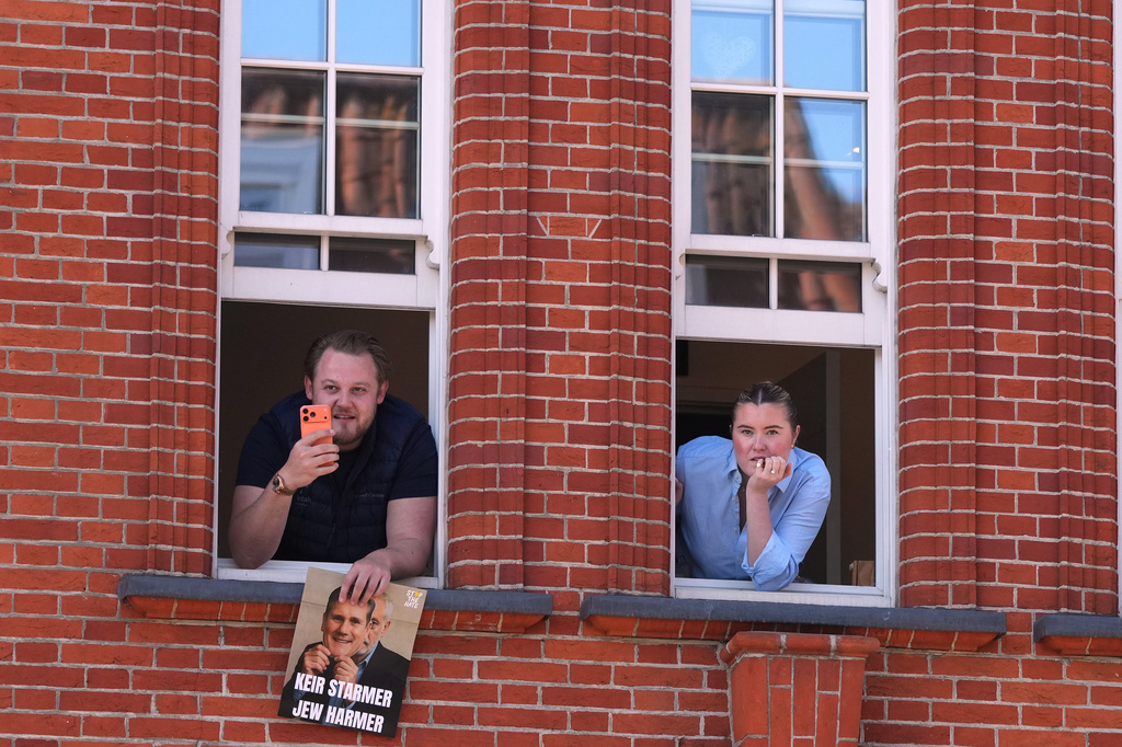 People look out of a window near the scene where two people were stabbed the previous day in the Golders Green neighbourhood, which has a large Jewish community, in London, Thursday, April 30, 2026. (AP Photo/Alastair Grant)