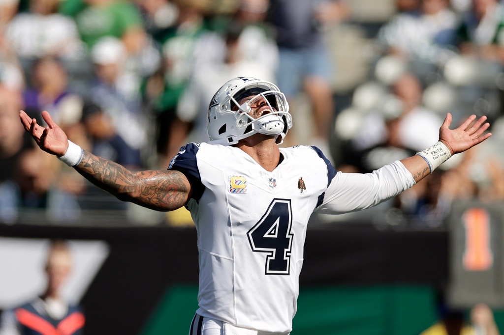 Dallas Cowboys' Dak Prescott reacts to a touchdown run by Javonte Williams during the first half of an NFL football game against the New York Jets Sunday, Oct. 5, 2025, in East Rutherford, N.J. (AP Photo/Adam Hunger)