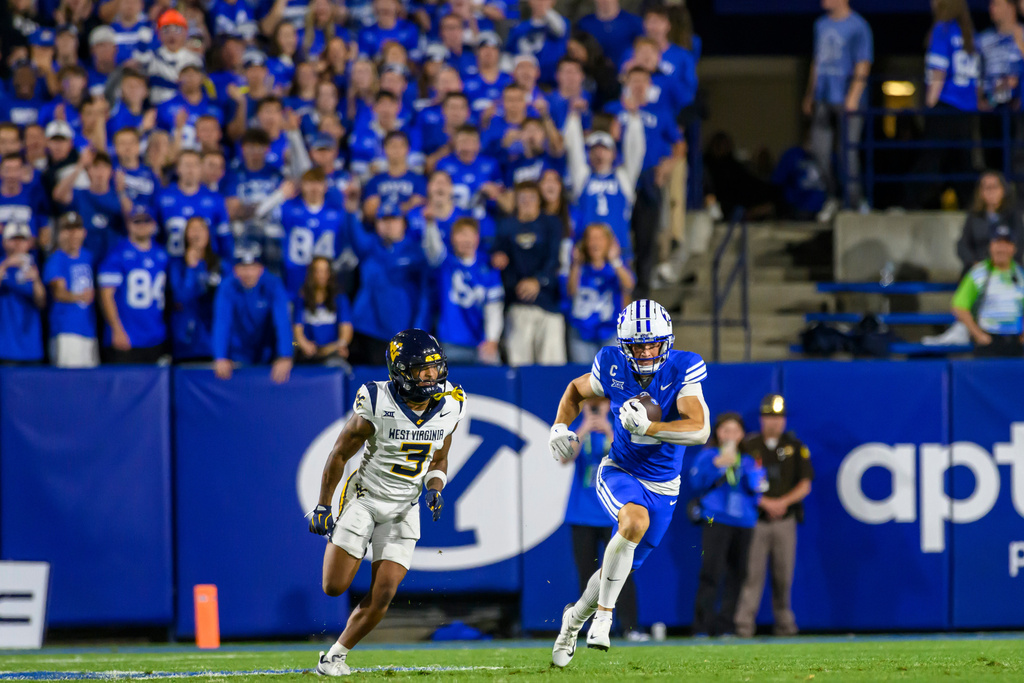 BYU wide receiver Chase Roberts (2) makes the catch over the defense of West Virginia cornerback Michael Coats Jr. (3) during the first half of an NCAA college football game, Friday, Oct. 3, 2025, in Provo, Utah. (AP Photo/Tyler Tate)