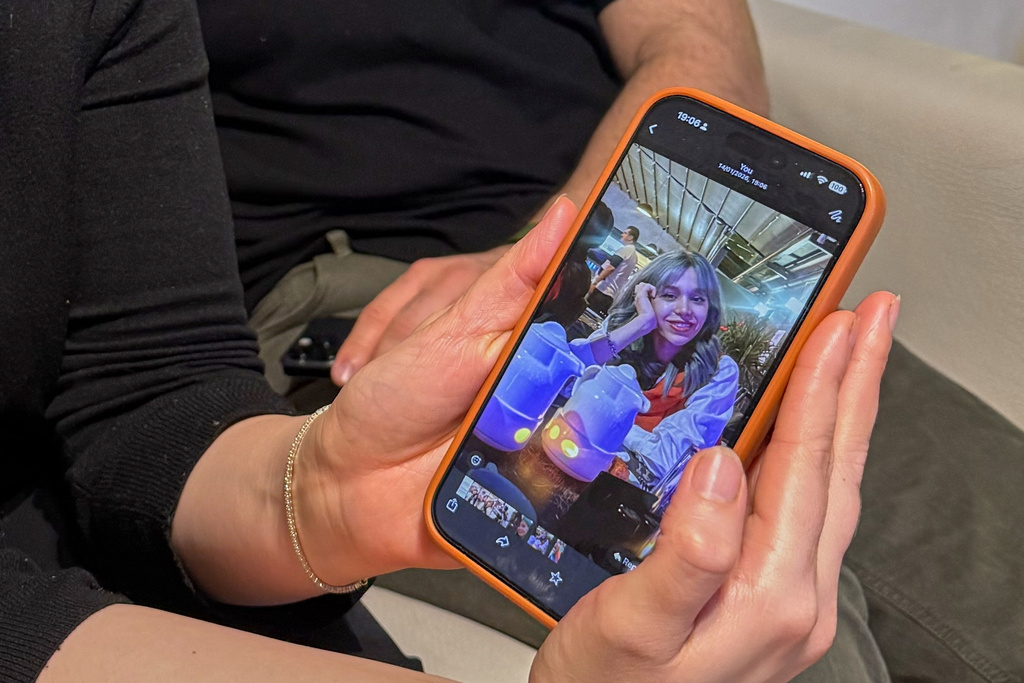 Hali Norei shows a picture of her 23-year-old niece Robina Aminian as she gives an interview alongside her partner Nezar Minoei, in Oslo, Norway, Wednesday, Jan. 14, 2025. Aminian, a university student, was killed during Iran's protests. (AP Photo/Bjornar Verpeide)