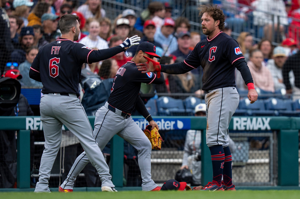 Cleveland Guardians' Rhys Hoskins, right, is congratulated by teammates David Fry, left, and Brayan Rocchio, center, after his RBI double during the sixth inning of a baseball game against the Philadelphia Phillies, Sunday, May 24, 2026, in Philadelphia. (AP Photo/Chris Szagola)